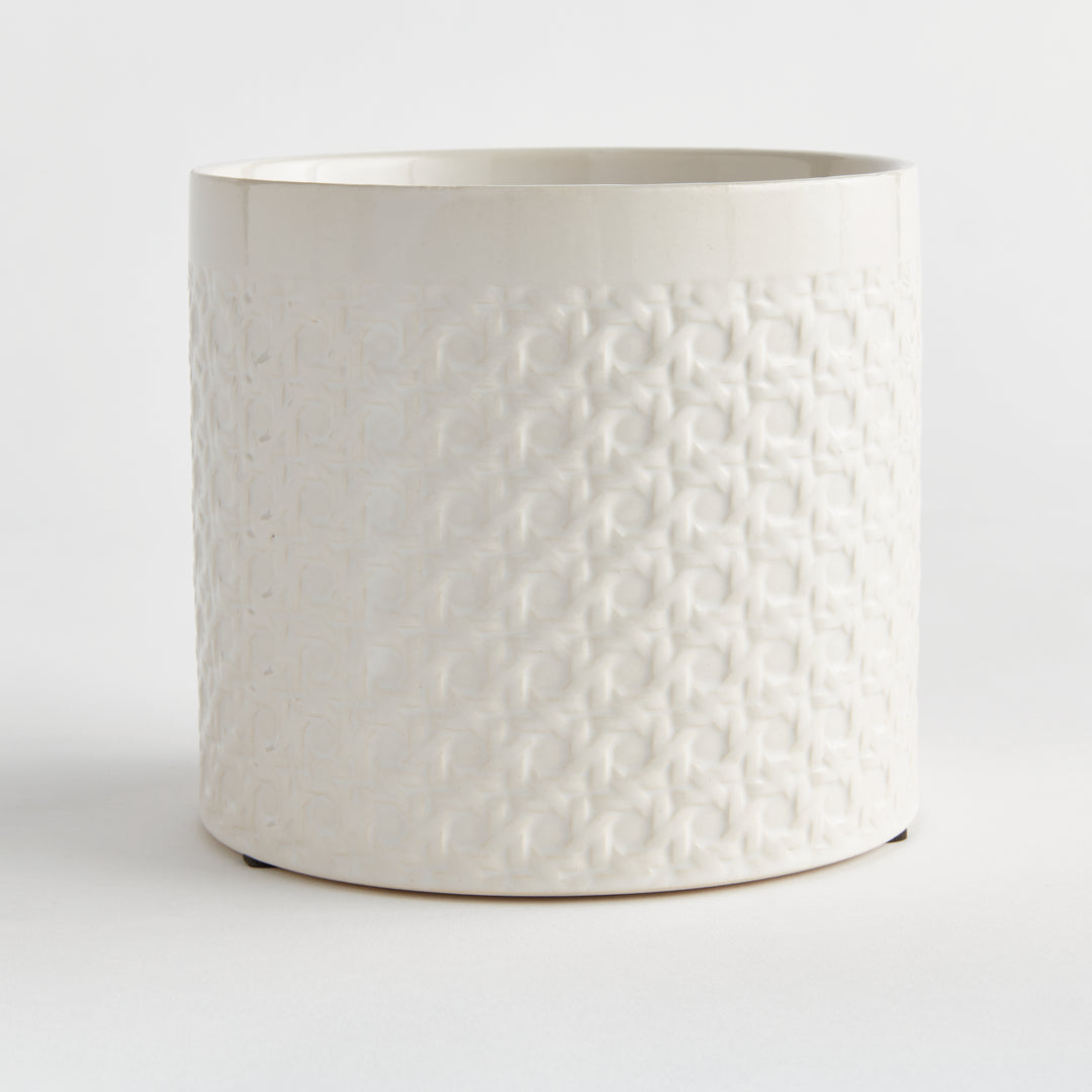 Angled view of a white round ceramic planter showing raised lattice texture across the cylindrical body on white, Traditional