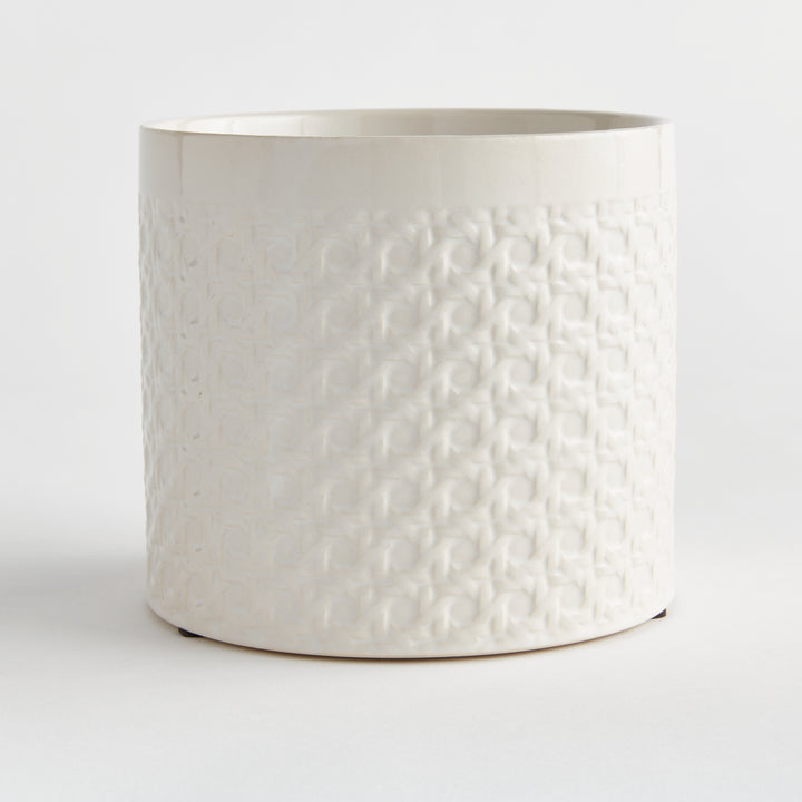 Angled view of a white round ceramic planter showing raised lattice texture across the cylindrical body on white, Traditional