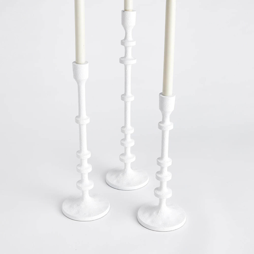 Three white taper candle holders shown together from an angled view, textured matte finish and sculptural column stems – Modern Farmhouse.
