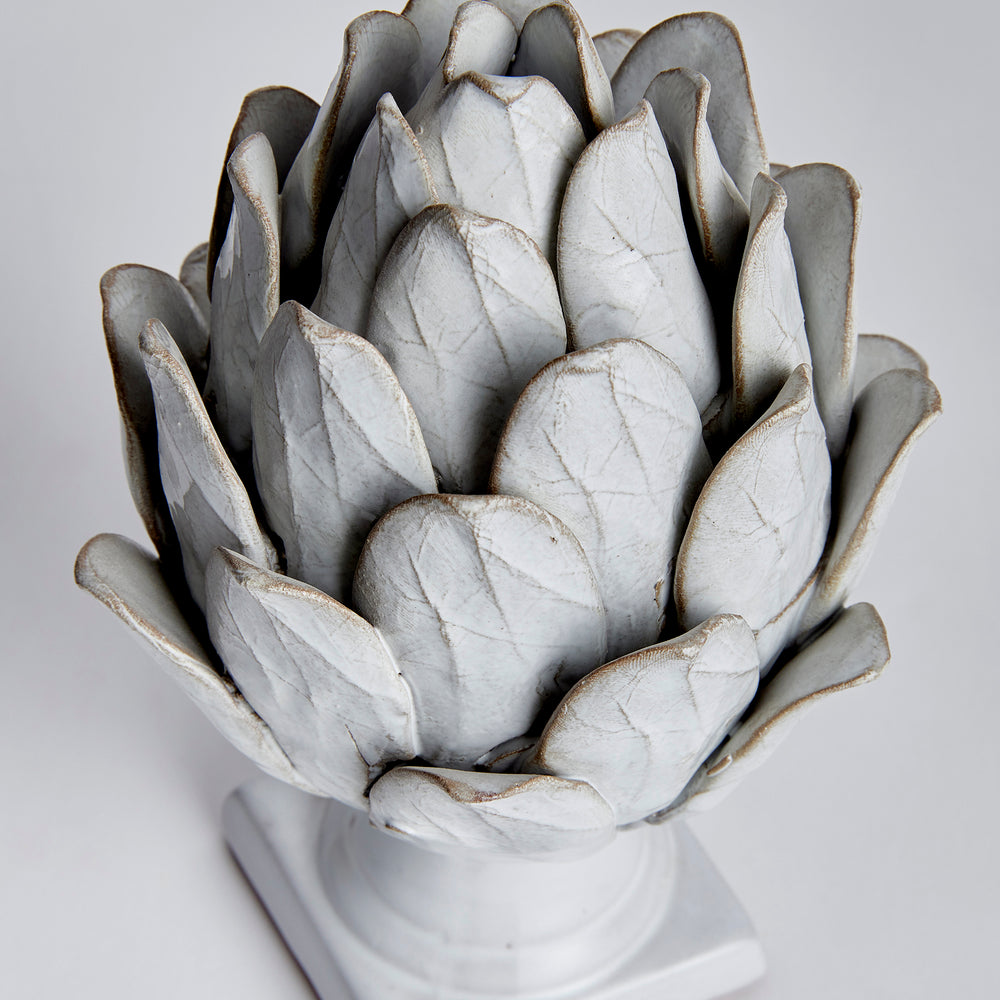 Small white terracotta artichoke finial detail showing overlapping leaves and veining in its reactive glaze - Transitional