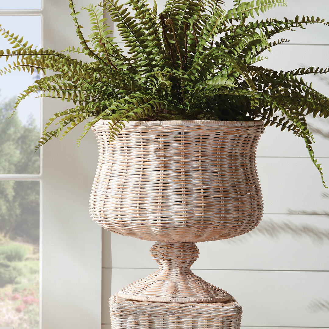 Handwoven wide whitewash rattan footed urn styled with faux fern stems for relaxed coastal home décor – Coastal.