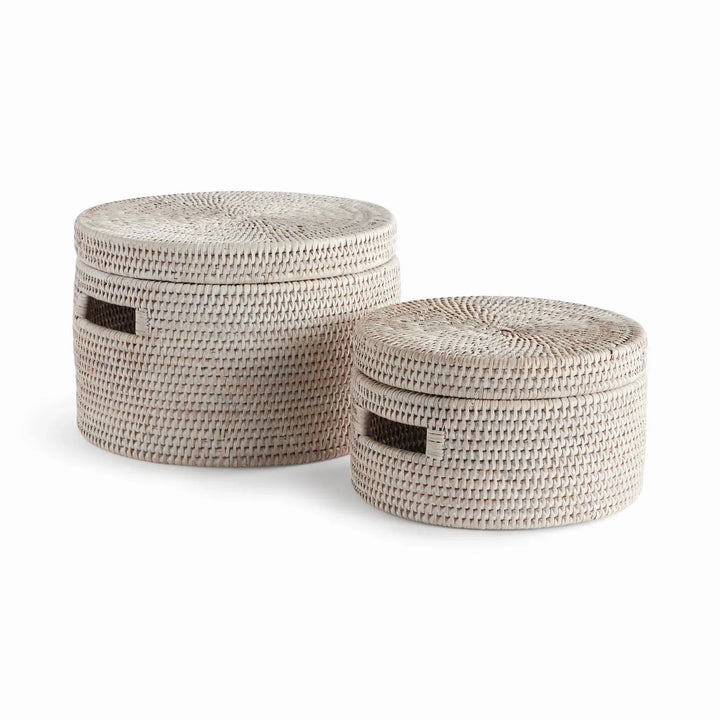 Whitewash handwoven rattan round lidded boxes with cutout handles, shown as a graduated set on white, Coastal Transitional