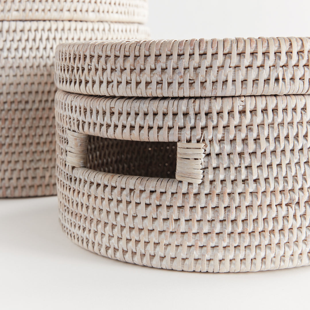 Close view of whitewash rattan boxes showing the weave, fitted lid edge and cutout handle on white, Coastal Transitional
