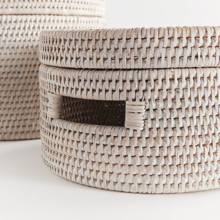 Close view of whitewash rattan boxes showing the weave, fitted lid edge and cutout handle on white, Coastal Transitional