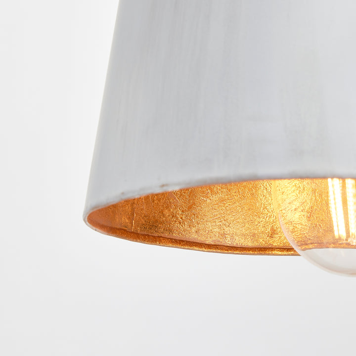 Whitewashed bottle pendant shade viewed from below, showing its gold interior beneath the pale metal rim, Transitional style