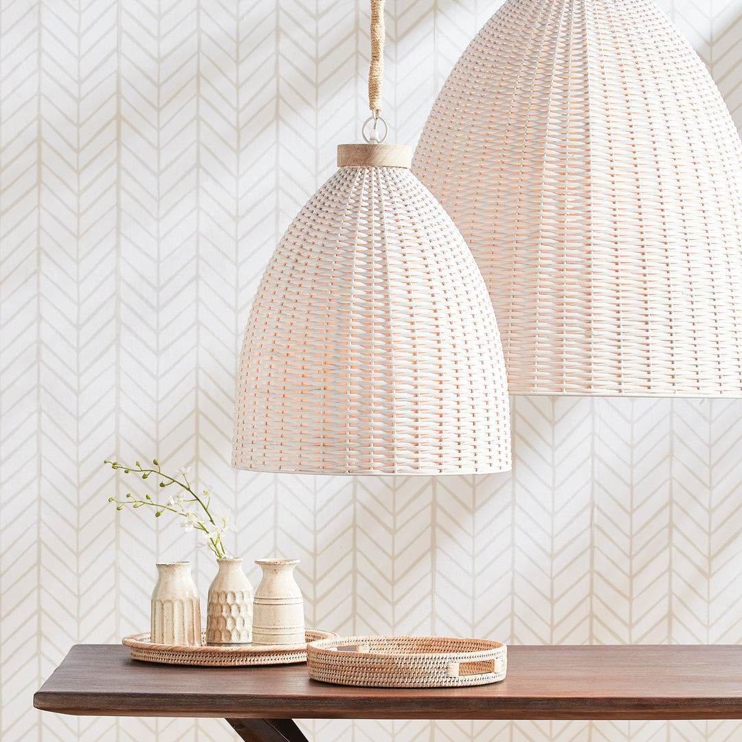 Whitewashed rattan pendant pair above a wood console with pale ceramic vessels, greenery and a round tray, Transitional style