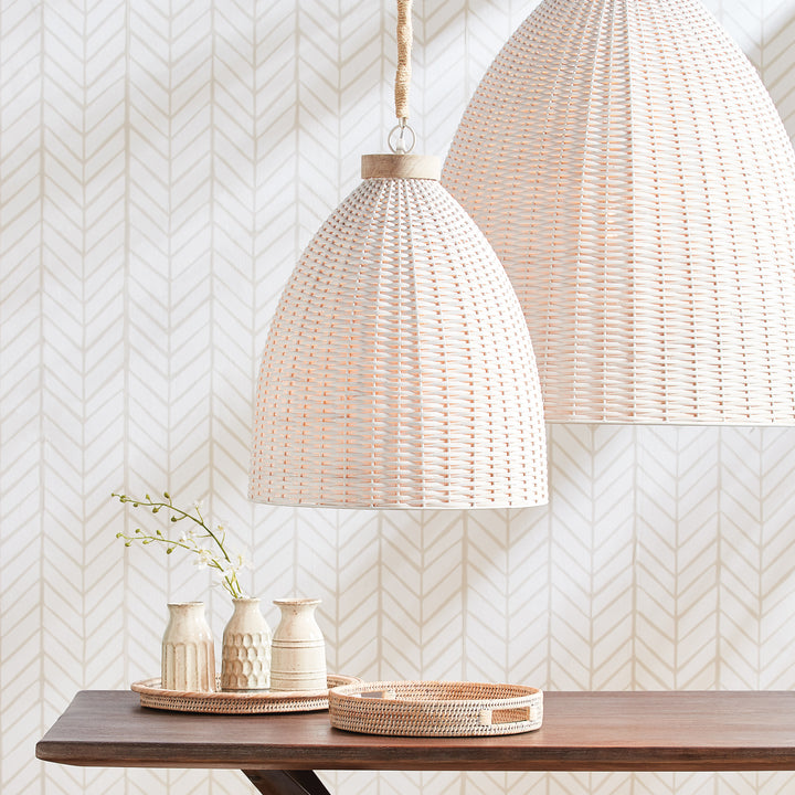 Whitewashed rattan pendant pair above a wood console with pale ceramic vessels, greenery and a round tray, Transitional style