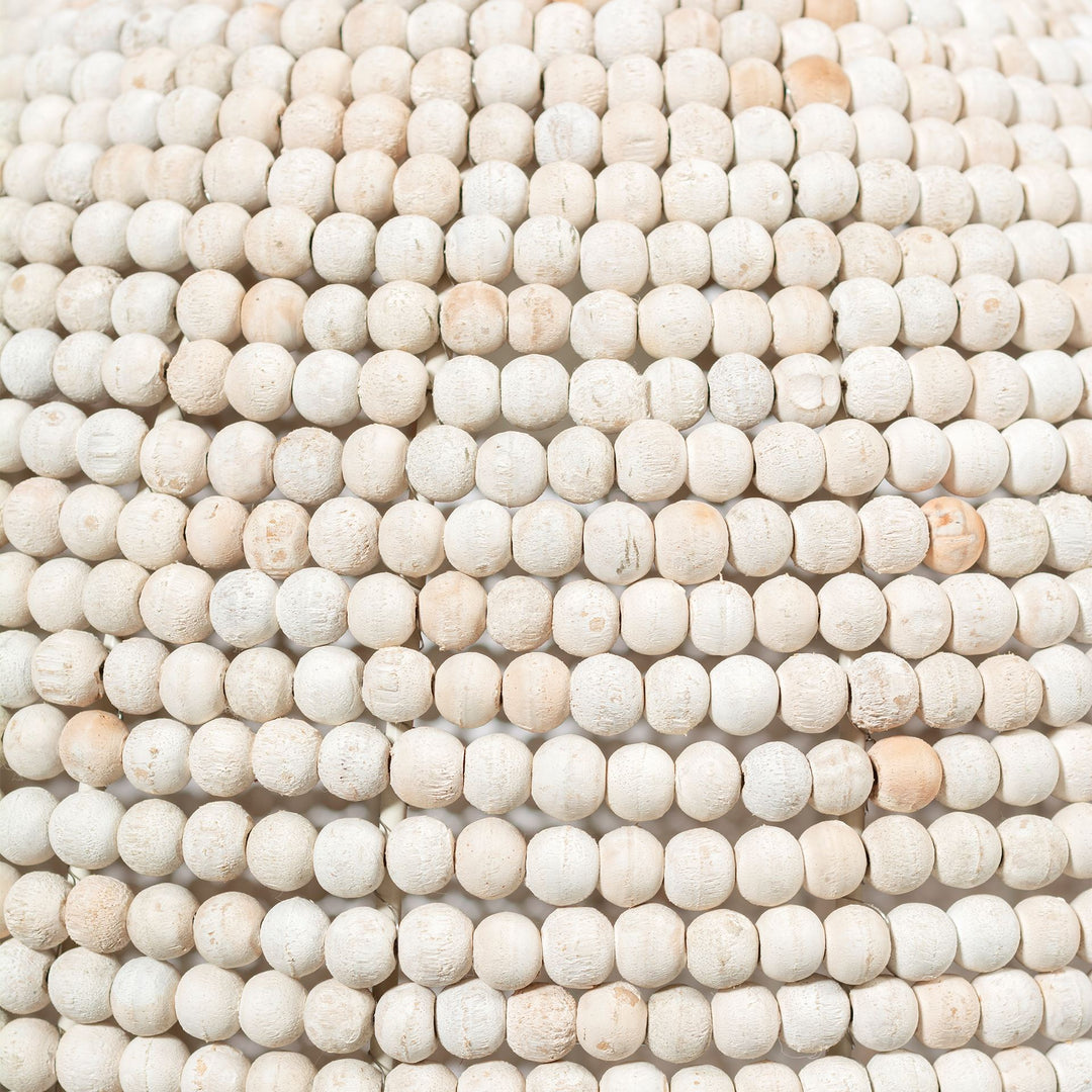 Whitewashed wood beads on the pendant shade shown close up, revealing rounded shapes and variations in pale tones – Coastal