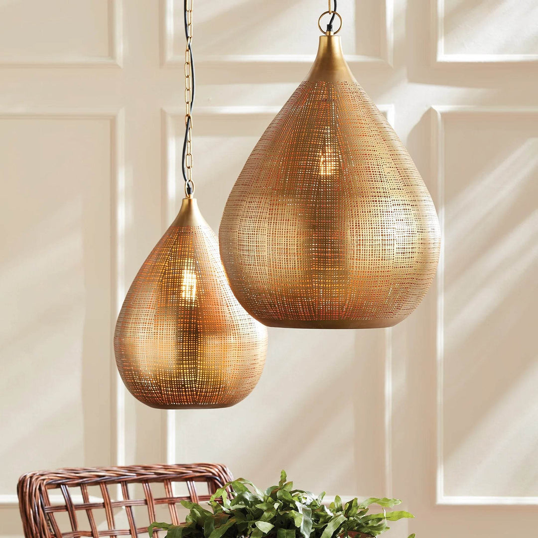 Small and large gold woven iron teardrop pendants shown together above a table, with greenery below them, Transitional style