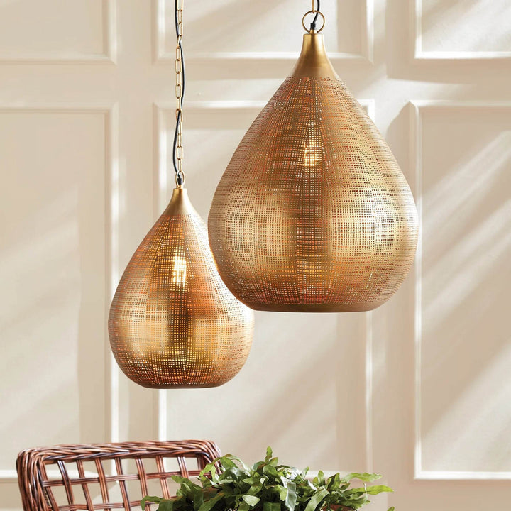 Small and large gold woven iron teardrop pendants shown together above a table, with greenery below them, Transitional style