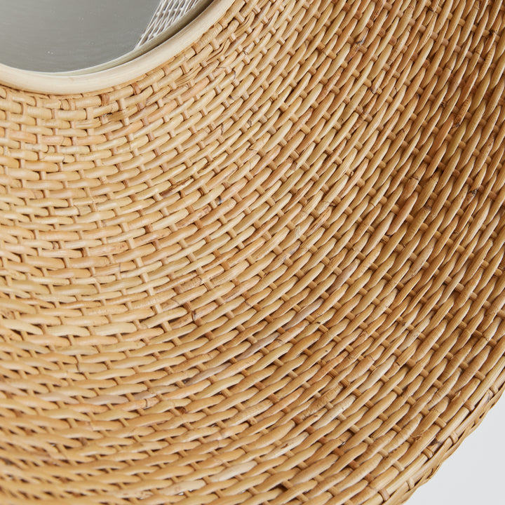Close-up view of handwoven natural rattan texture on a deep, circular mirror frame

