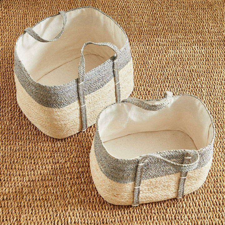 Woven rectangular storage baskets set on textured rug, neutral gray and natural tones, ideal for living room or bedroom storage.

