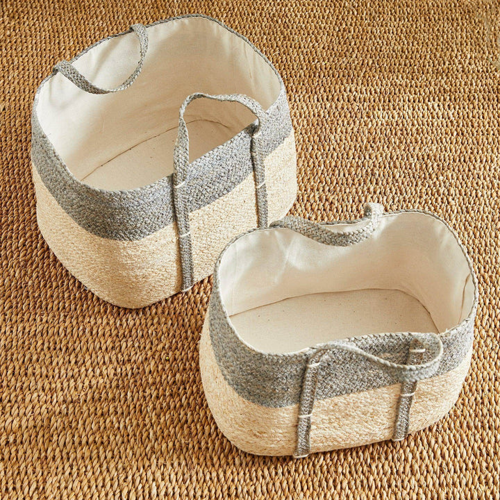 Woven rectangular storage baskets set on textured rug, neutral gray and natural tones, ideal for living room or bedroom storage.

