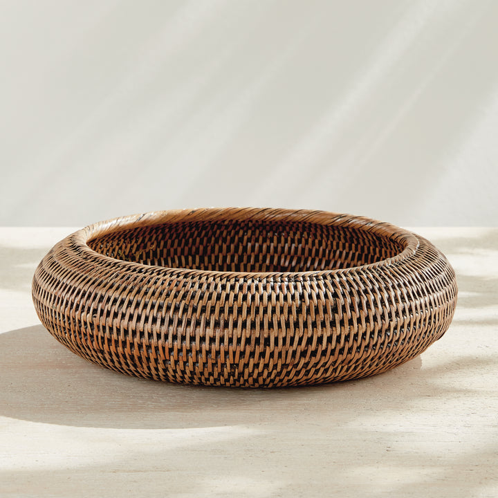 Brown rattan shallow display bowl shown unfilled on a tabletop, with a broad opening and curved rim - Coastal Transitional