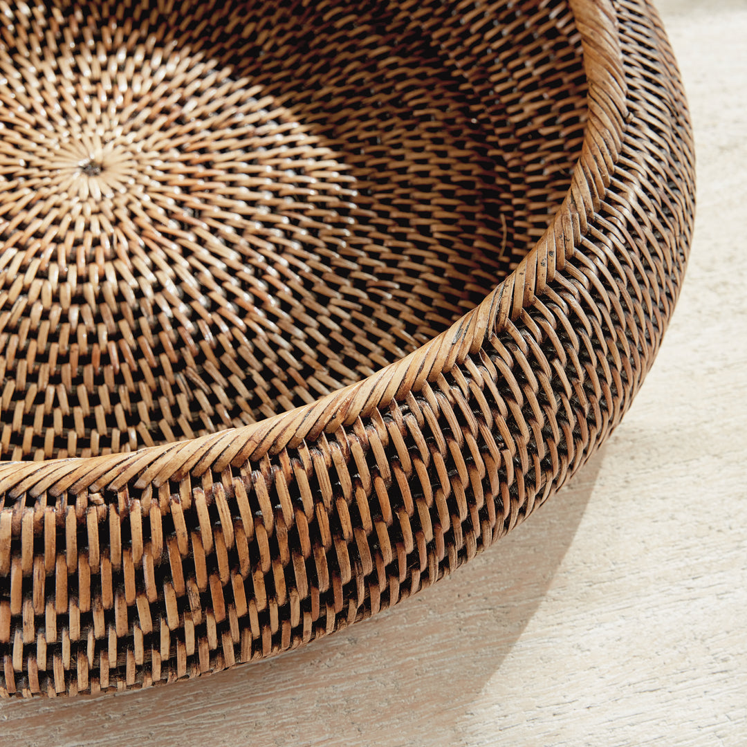 Brown rattan shallow display bowl close-up showing the thick wrapped rim and patterned woven base - Coastal Transitional