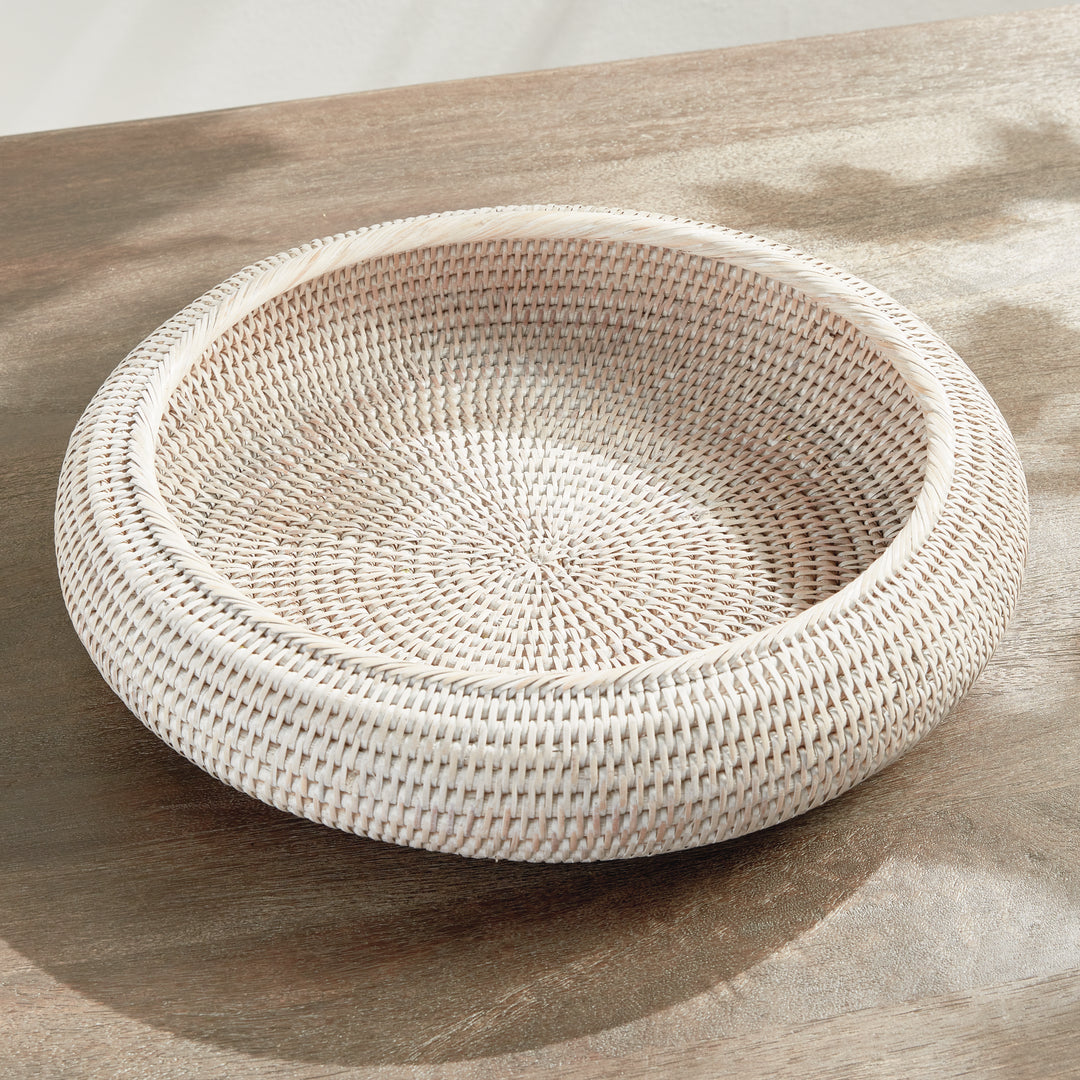 Whitewash rattan shallow display bowl viewed from above on a tabletop, showing its empty woven base - Coastal Transitional