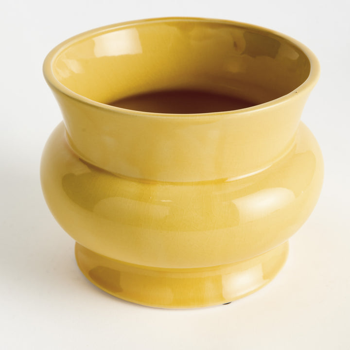 Yellow ceramic cachepot with rounded footed silhouette and glossy reactive glaze shown from an alternate angle – English Country