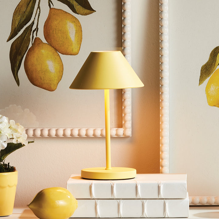Yellow cordless LED table lamp with metal empire shade styled on shelving with books and decorative objects – Contemporary